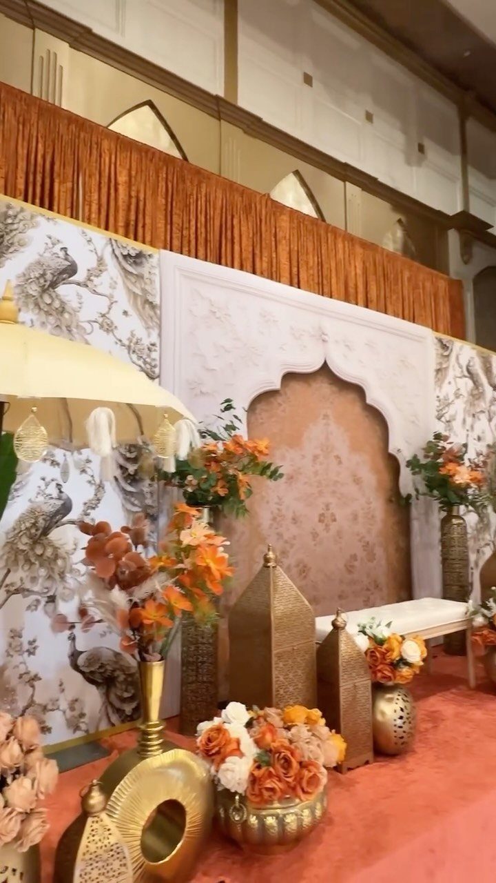 21 Color Combinations for Wedding Palettes in 2026 7 Peach and gold wedding stage decor with lanterns and floral arrangements.