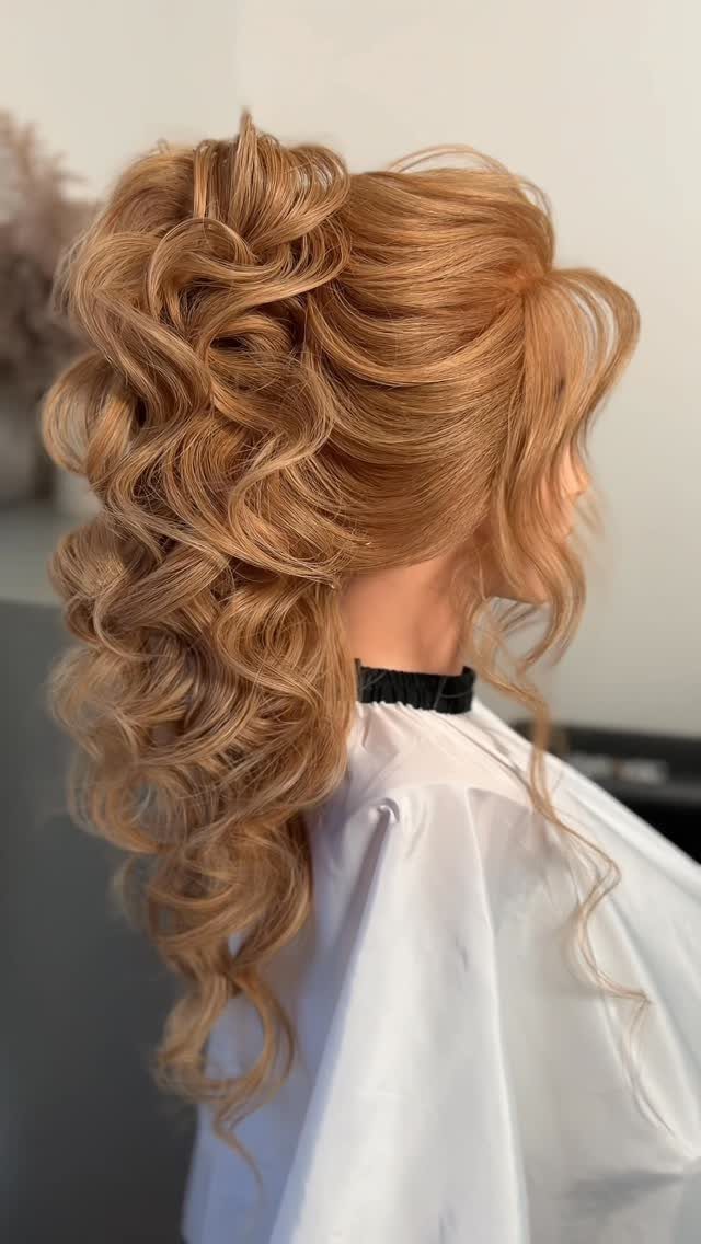 Voluminous strawberry blonde curly ponytail cascading down the back of a person.