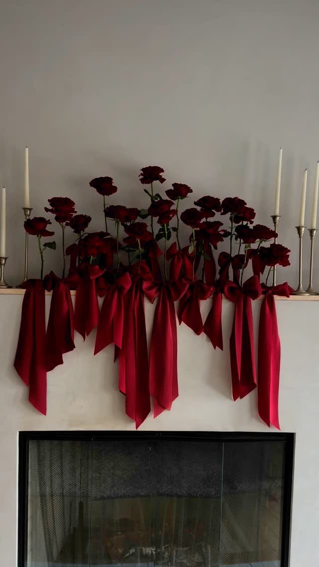 12 Dark Red Wedding Theme Ideas With Floral, Cake and Gown Picks 7 Red roses with long hanging red satin bows decorating a white fireplace mantelpiece.