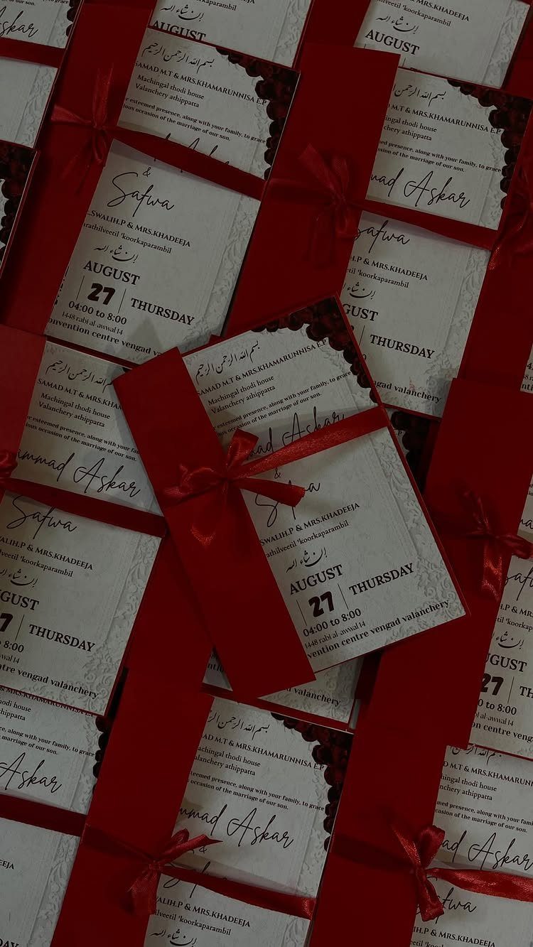 12 Dark Red Wedding Theme Ideas With Floral, Cake and Gown Picks 2 White wedding invitations with red scalloped edges and red ribbon bows arranged in rows.