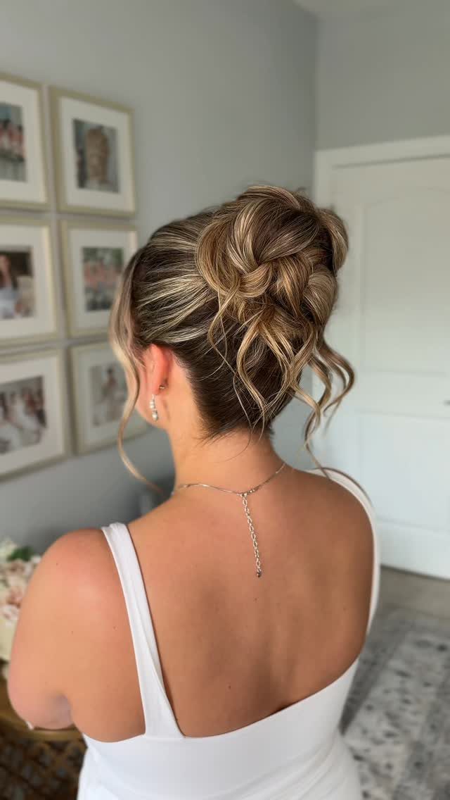 Woman with blonde hair styled in a textured, loose updo and curled strands.