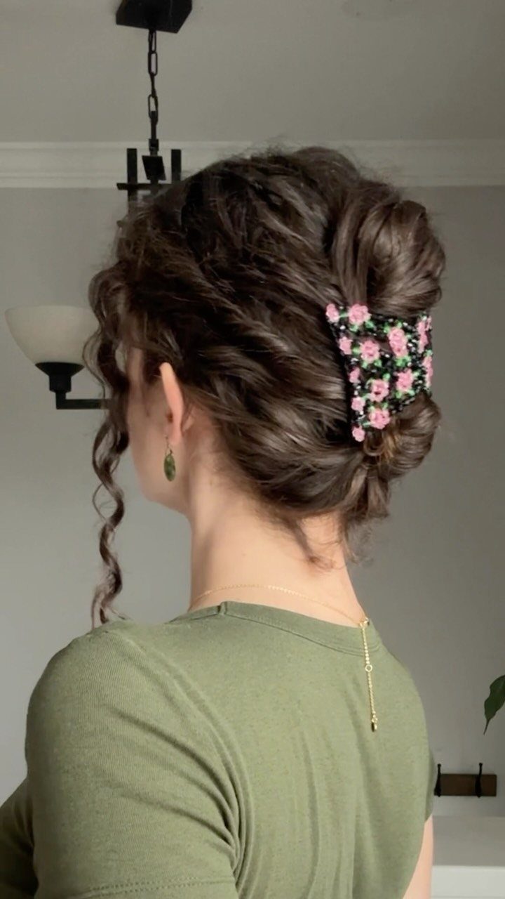 10 Easy Updos for Medium Hair for Wedding Guest Season 2026 10 Woman with curly hair styled in a textured updo with a floral claw clip.