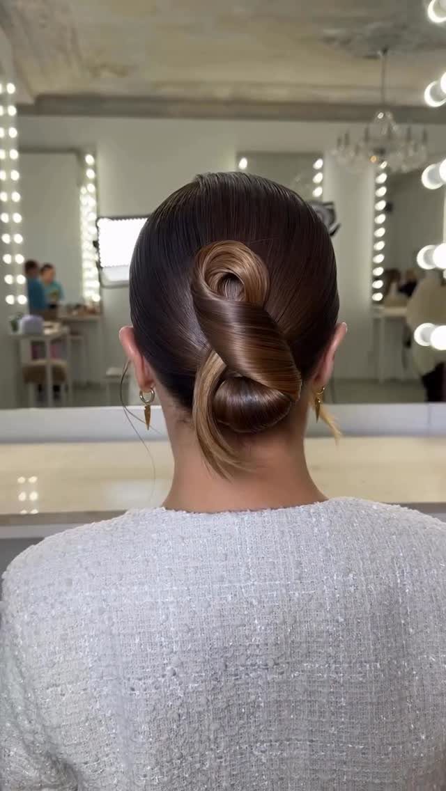 10 Easy Updos for Medium Hair for Wedding Guest Season 2026 6 A woman with a sleek, polished brown hair twisted bun hairstyle in a salon.