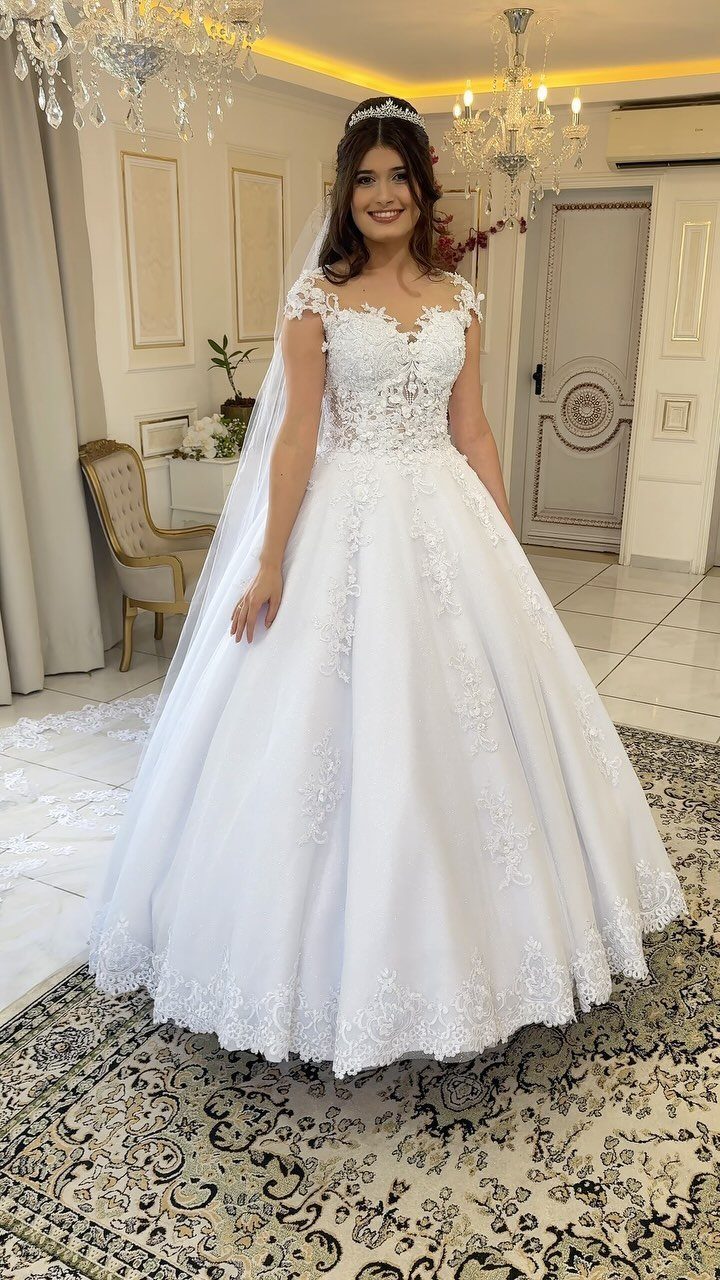 Elegant Princess Wedding Dress Styles in 27 Ideas 19 Woman in a white princess wedding dress with lace details and a tiara.