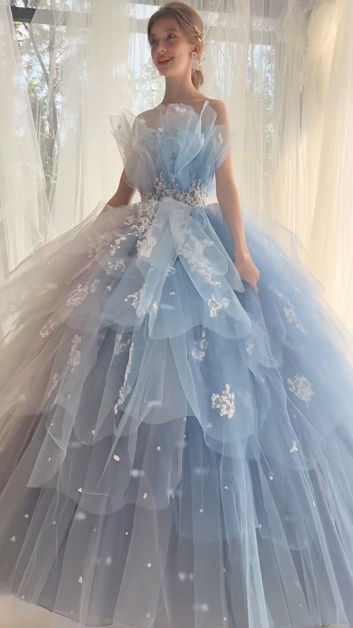 Elegant Princess Wedding Dress Styles in 27 Ideas 23 Woman in a voluminous light blue tiered tulle gown with white floral embroidery.