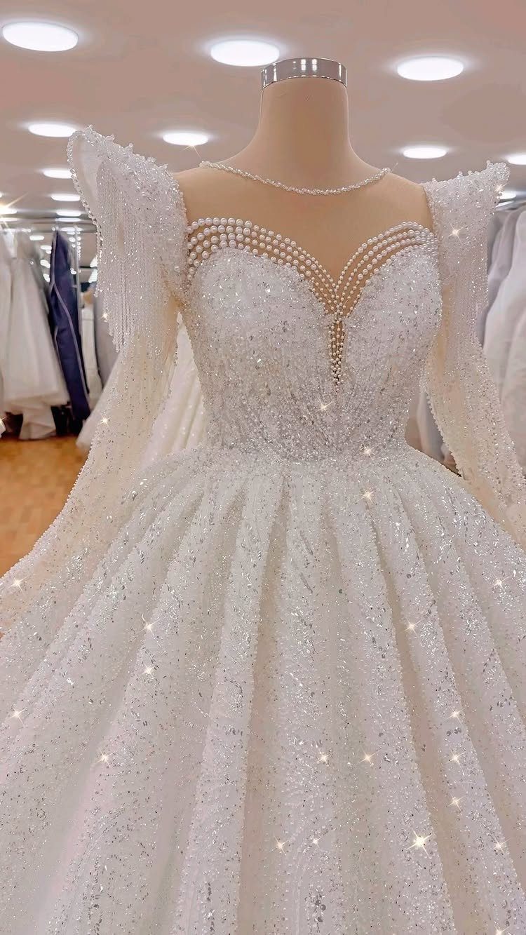 Elegant Princess Wedding Dress Styles in 27 Ideas 7 White sparkling wedding dress with long sleeves and pearl neckline on a mannequin
