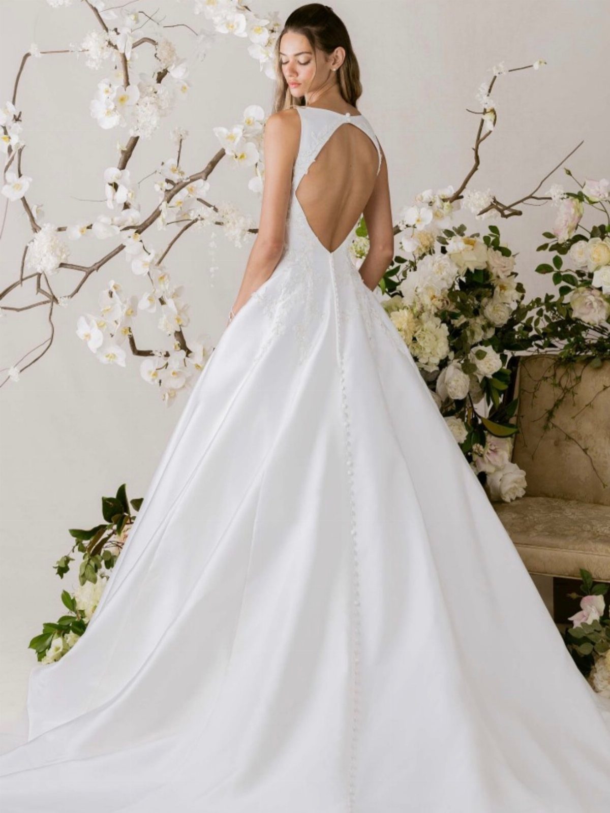 Elegant Princess Wedding Dress Styles in 27 Ideas 17 Woman in a white wedding gown with a deep open back and full skirt.