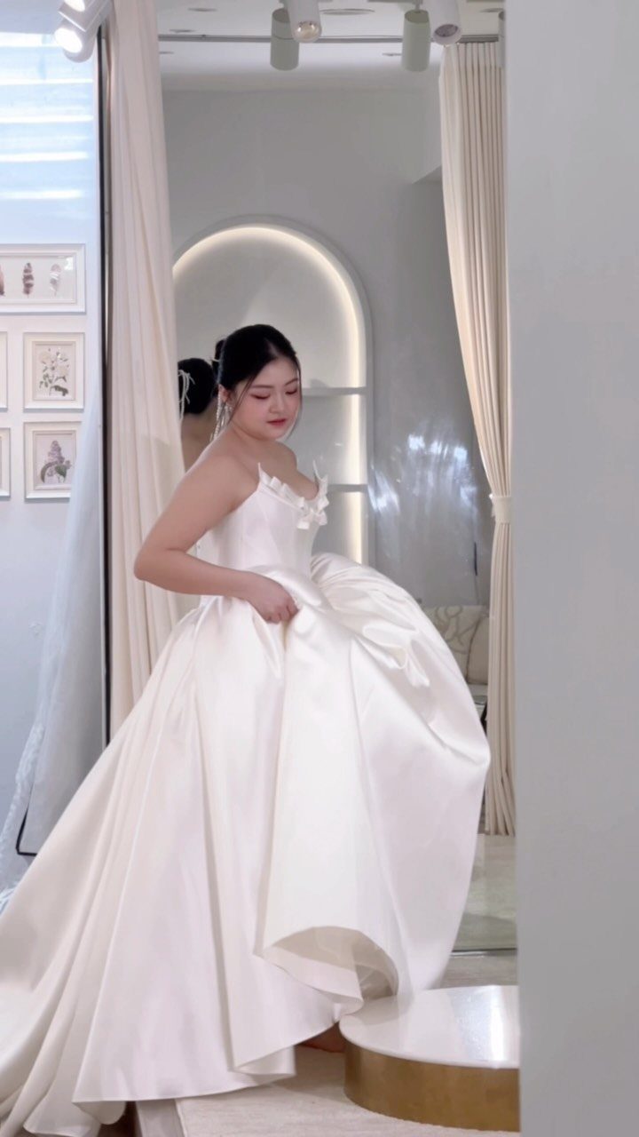 Elegant Princess Wedding Dress Styles in 27 Ideas 2 Woman wearing a voluminous white satin wedding dress with a full princess silhouette.