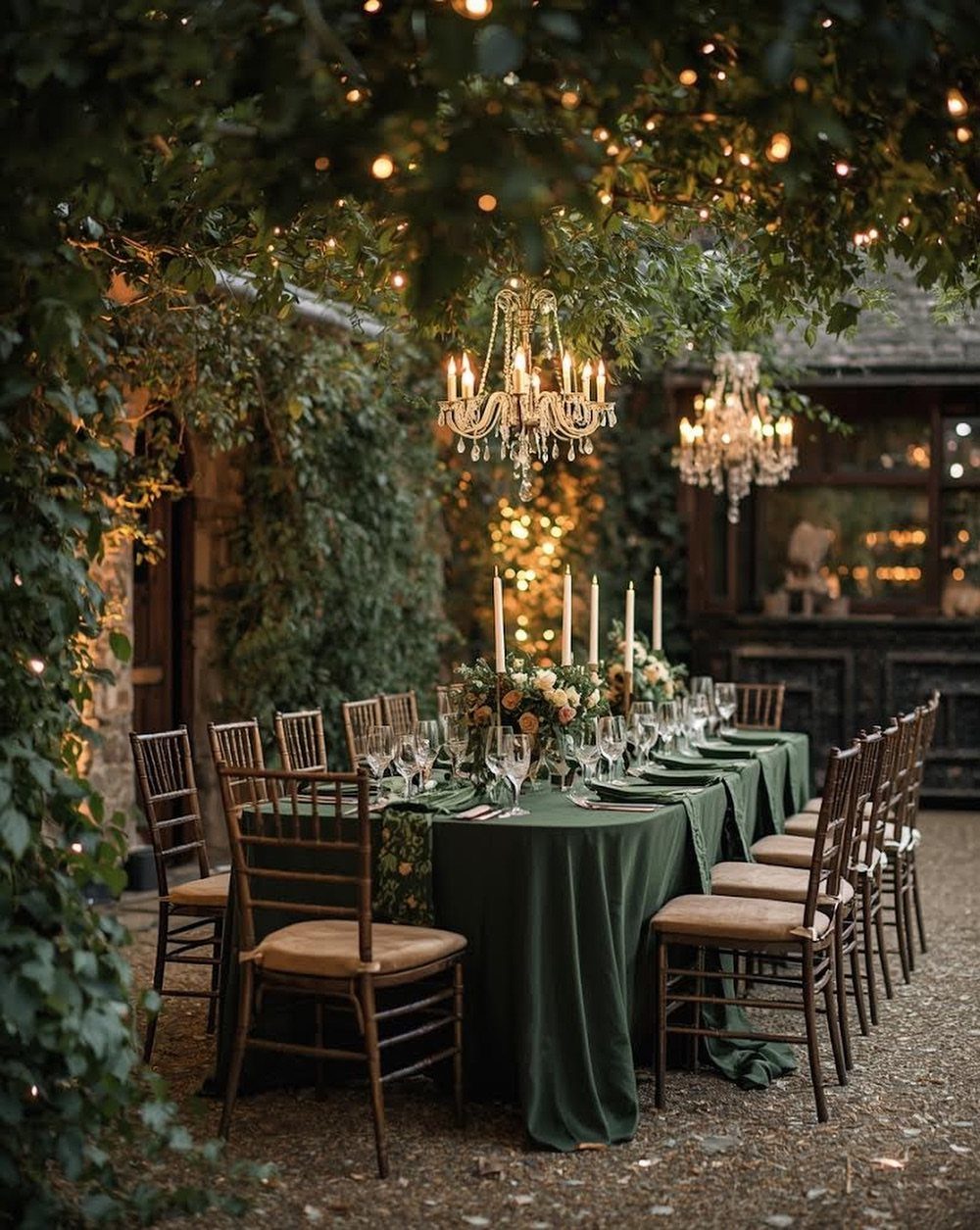 Enchanted Forest Theme Wedding: 12 Ideas for the Ceremony and Reception 5 A long outdoor dining table set under trees decorated with chandeliers and twinkling fairy lights.