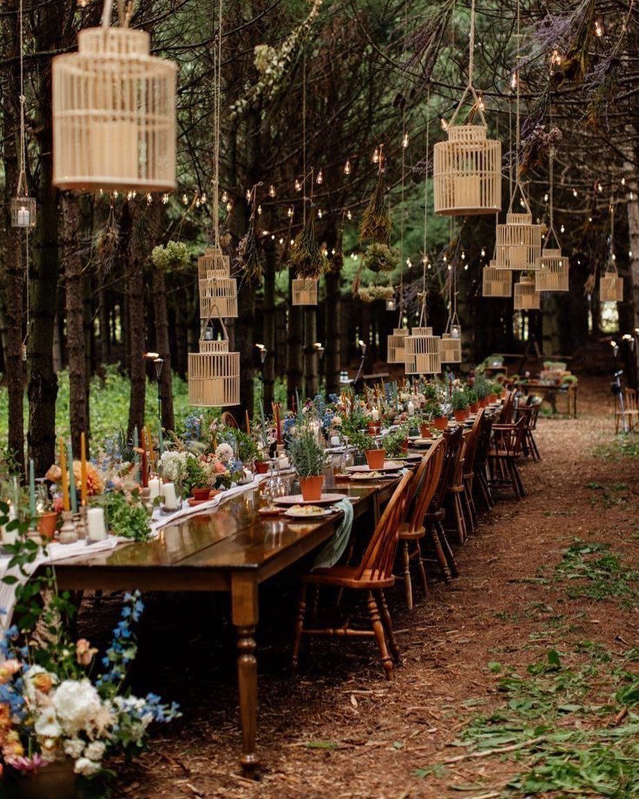 Enchanted Forest Theme Wedding: 12 Ideas for the Ceremony and Reception 13 A long wooden dining table decorated with flowers and candles in a forest setting.