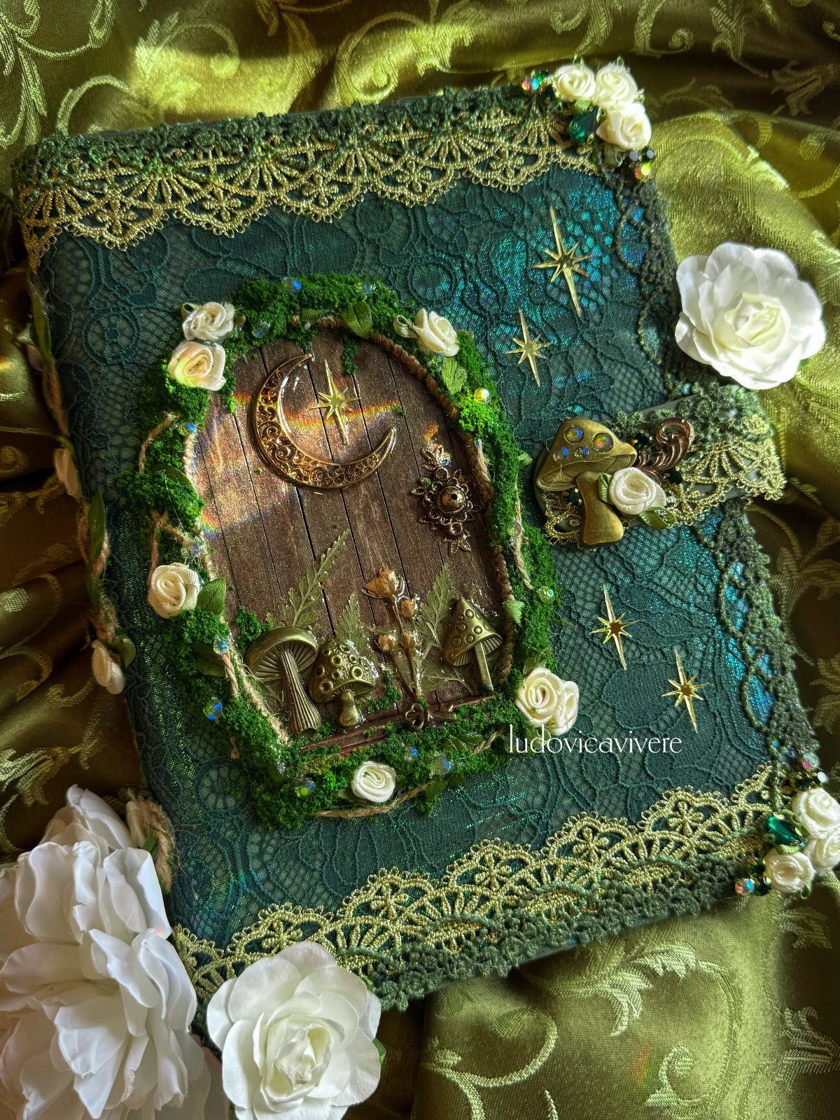 Enchanted Forest Theme Wedding: 12 Ideas for the Ceremony and Reception 11 A decorative green book adorned with moss, white roses, and celestial moon motifs.