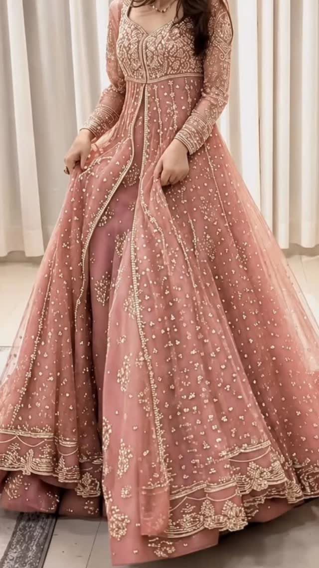 Blush pink long-sleeved gown with gold embroidery and sequins on a full skirt.