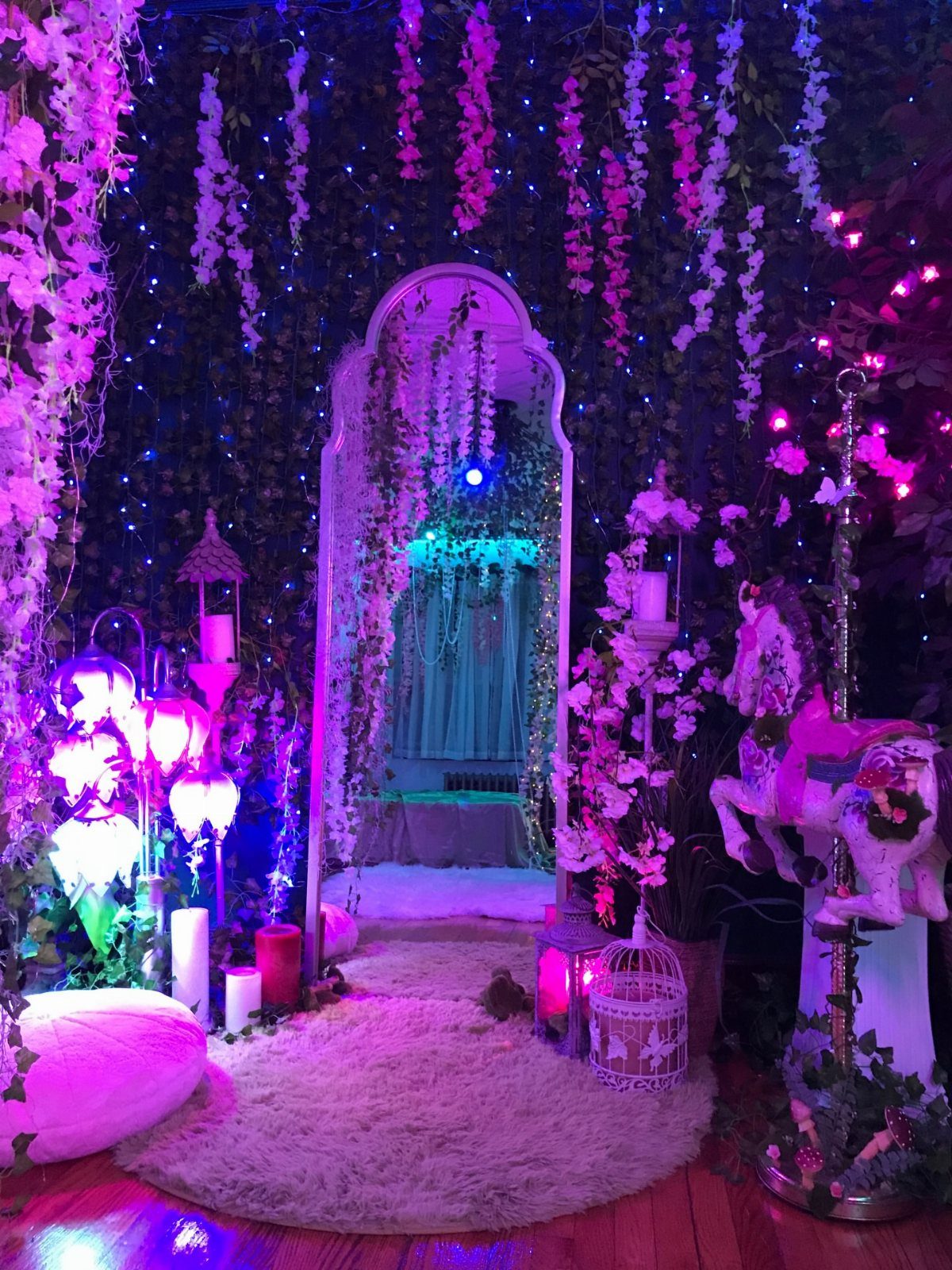 Fantasy Inspired Wedding: 9 Ideas from Forest Photos to Celestial Lace 5 A fantasy-themed photo booth setup with purple lighting, floral vines, and a carousel horse.