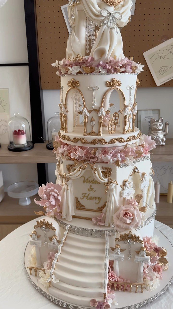 Fantasy Inspired Wedding: 9 Ideas from Forest Photos to Celestial Lace 6 A large, ornate white wedding cake with gold accents and pink roses on a silver platter.
