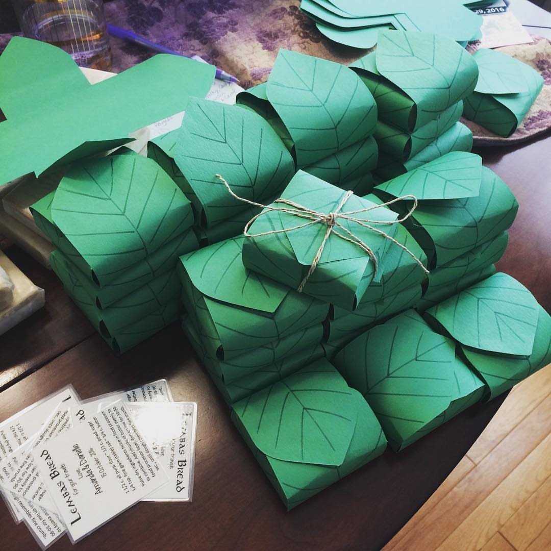 Fantasy Inspired Wedding: 9 Ideas from Forest Photos to Celestial Lace 3 Stacks of green leaf-shaped paper gift boxes tied with twine on a wooden table.