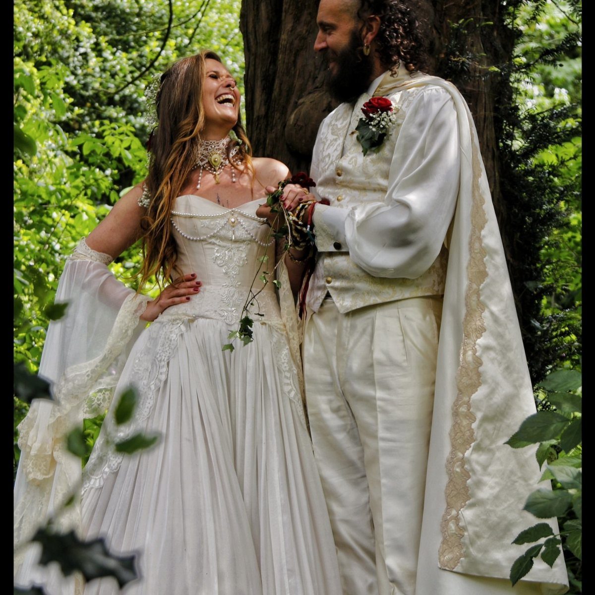 Fantasy Inspired Wedding: 9 Ideas from Forest Photos to Celestial Lace 2 A couple in medieval inspired wedding attire smiling at each other in a lush green forest.