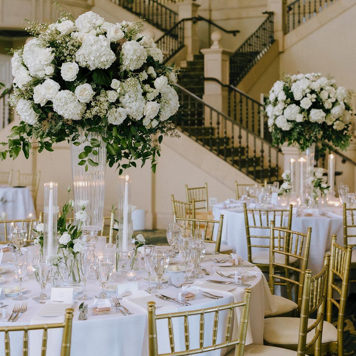 Flowers for Wedding Reception: 11 Elegant Ideas to Style Your Space 10 Tall white hydrangea and rose arrangement in a glass vase on a wedding table.