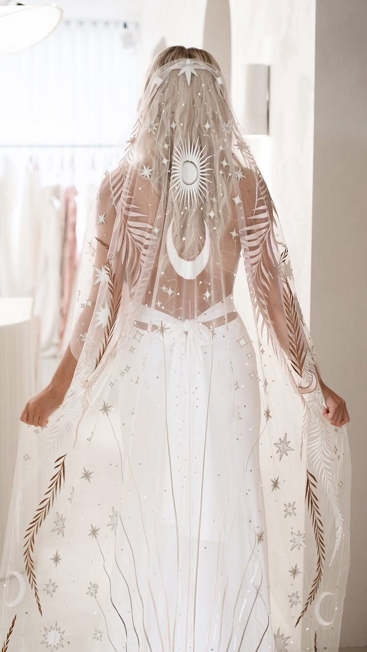 Goddess Wedding Dress Styles: 19 Ideas for 2026 8 Woman from behind wearing a white wedding dress and celestial embroidered gold veil.