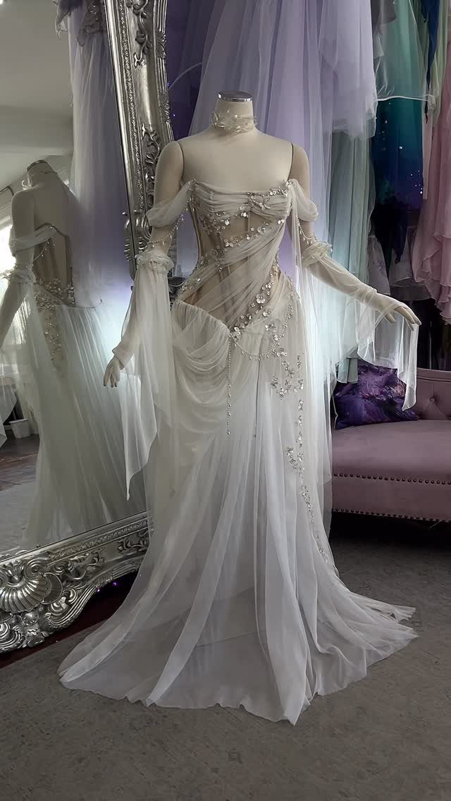 Goddess Wedding Dress Styles: 19 Ideas for 2026 14 White ethereal goddess wedding dress with flowing tulle and beads on a mannequin.