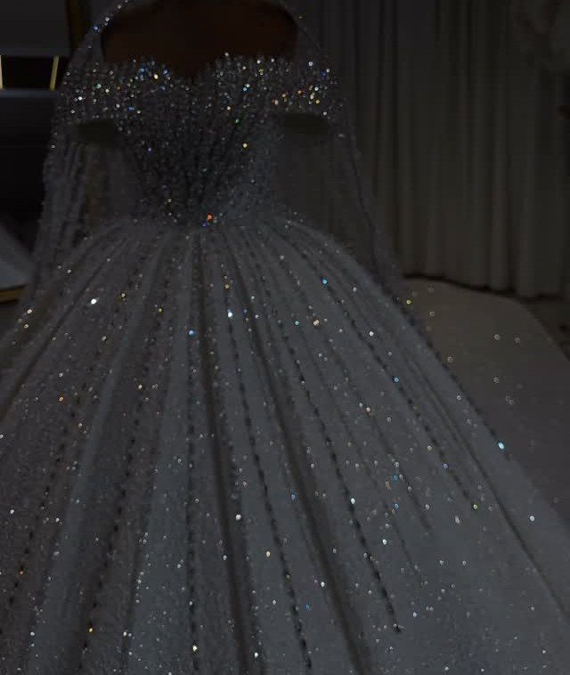 Goddess Wedding Dress Styles: 19 Ideas for 2026 19 Sparkling white ballgown wedding dress with a shimmering embellished bodice on a mannequin.