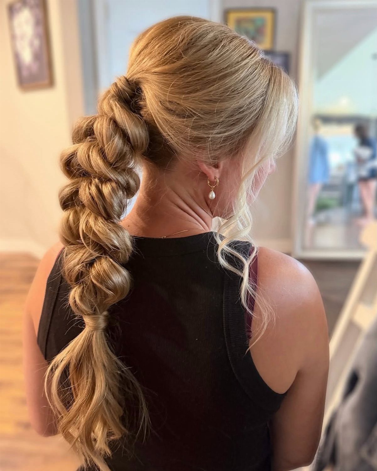 18 Hoco Updo Hairstyles From Braids to Sleek Buns 14 Blonde woman with a voluminous bubble braid ponytail styled in thick, rounded sections.