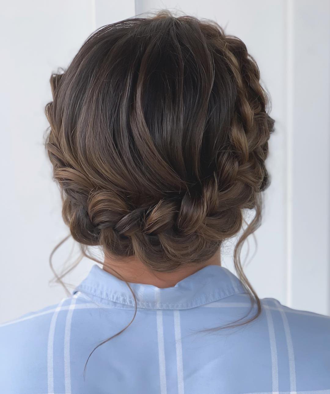 18 Hoco Updo Hairstyles From Braids to Sleek Buns 4 A person's brown hair styled in an intricate crown braid updo against a white background.