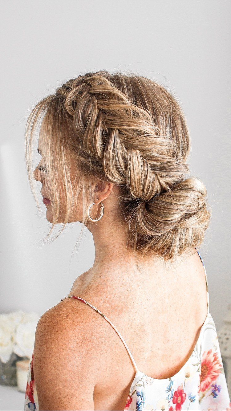 18 Hoco Updo Hairstyles From Braids to Sleek Buns 2 Blonde woman with a thick fishtail braid transitioning into a low textured bun.