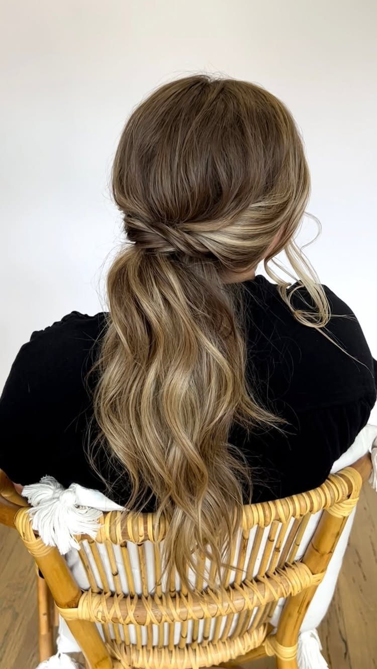18 Hoco Updo Hairstyles From Braids to Sleek Buns 16 Long wavy blonde hair styled in a low ponytail with a twisted hair detail.
