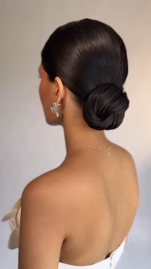 18 Hoco Updo Hairstyles From Braids to Sleek Buns 10 Woman with dark hair styled in a sleek, polished low bun.