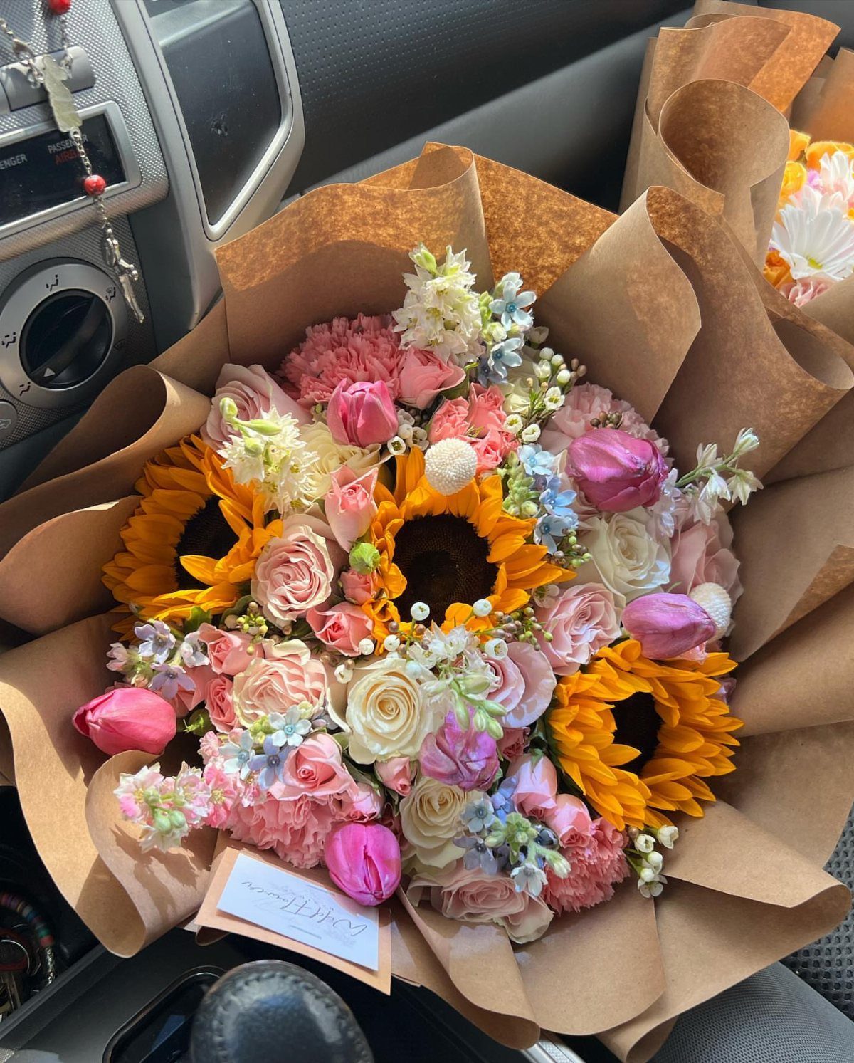 15 Ideas de Ramos de Flores for Every Table and Season 2 Colorful bouquet with sunflowers and pink roses wrapped in brown kraft paper.