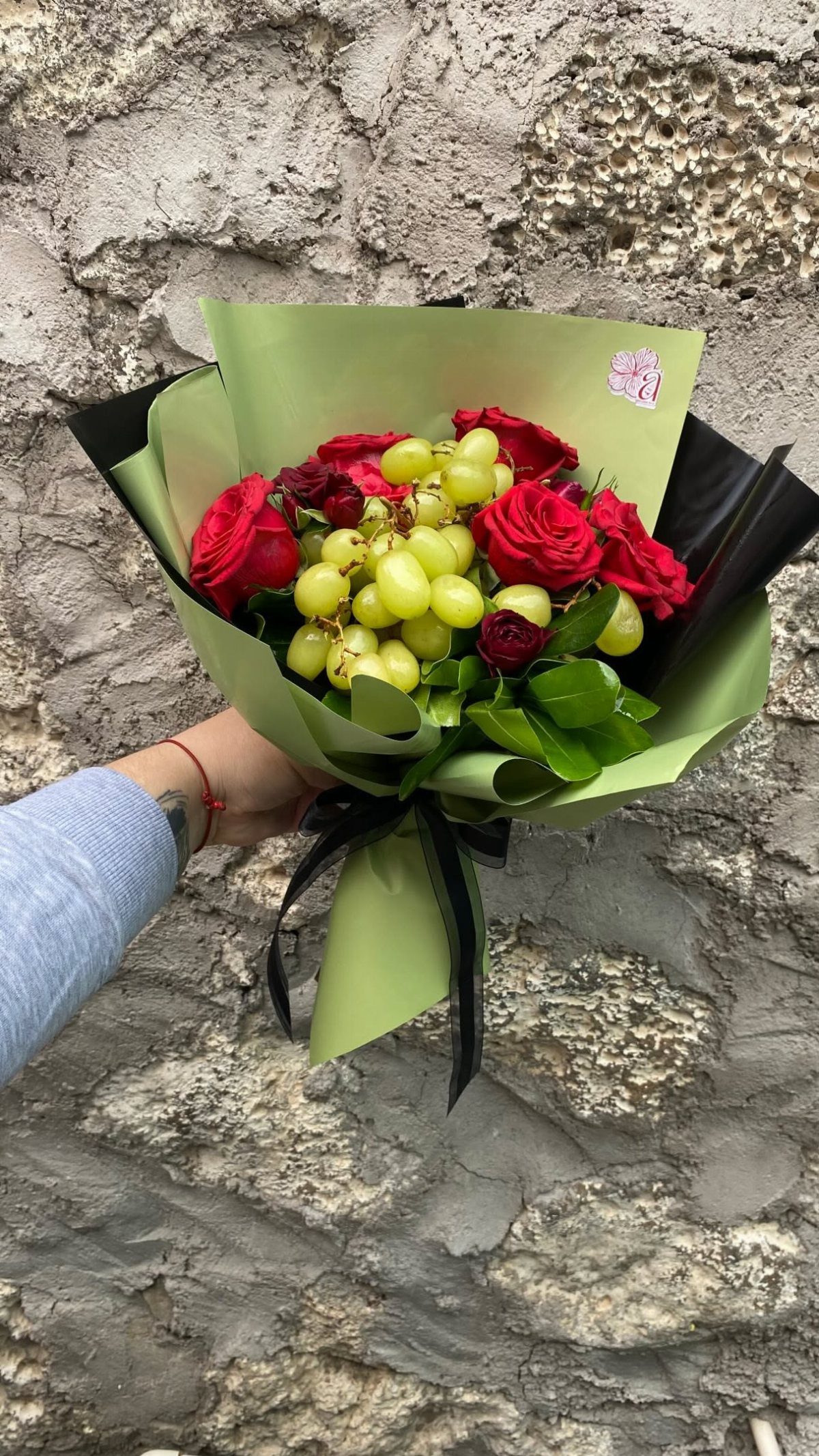15 Ideas de Ramos de Flores for Every Table and Season 11 Bouquet of red roses and green grapes wrapped in green and black paper.