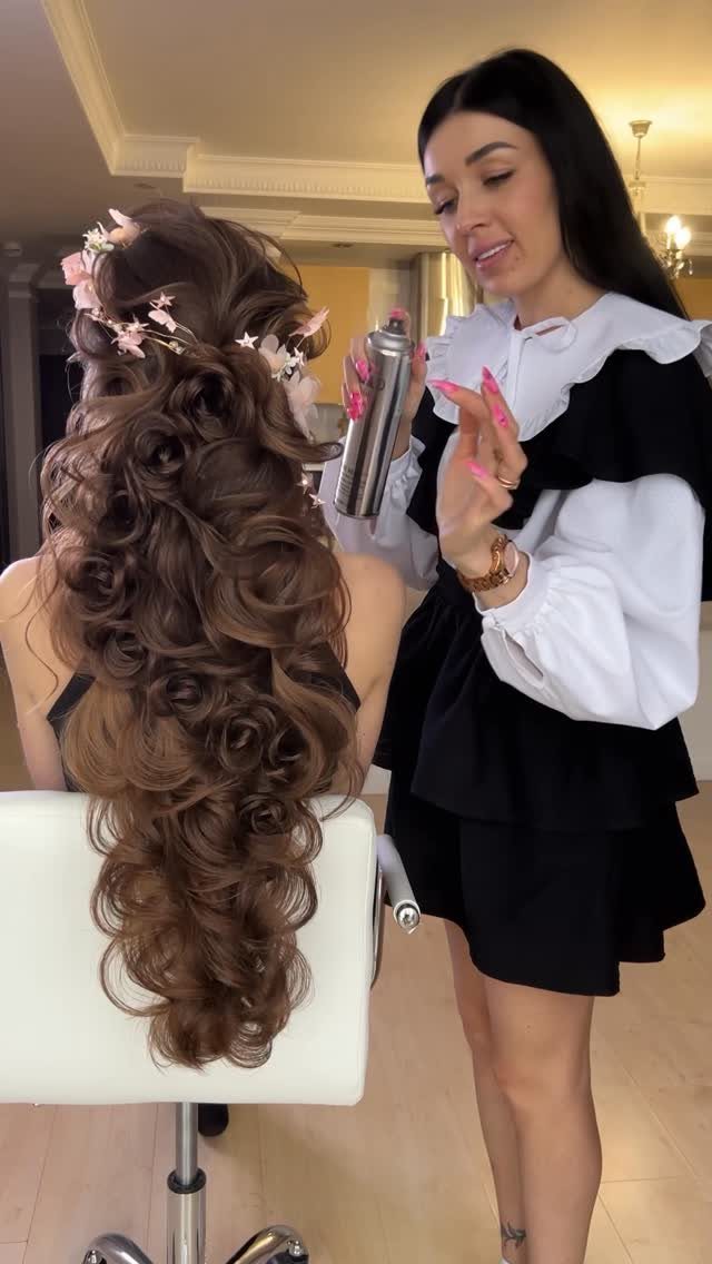 16 Long Hair Half Up Half Down Hairstyles for Real Life 15 Long brown hair styled in voluminous cascading curls with small pink floral hair accessories.