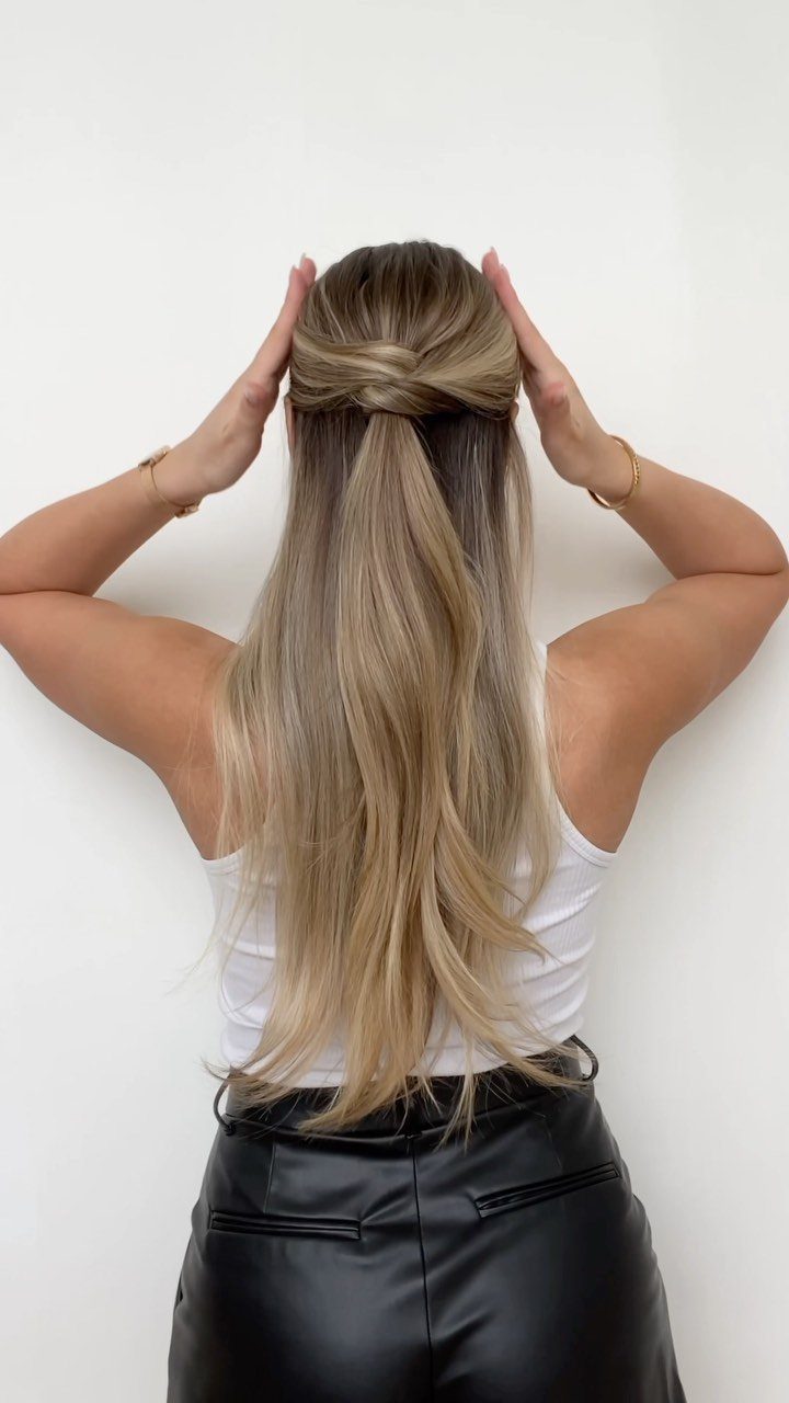 16 Long Hair Half Up Half Down Hairstyles for Real Life 17 Blonde woman showing a half-up half-down hairstyle with a small knot at the back.