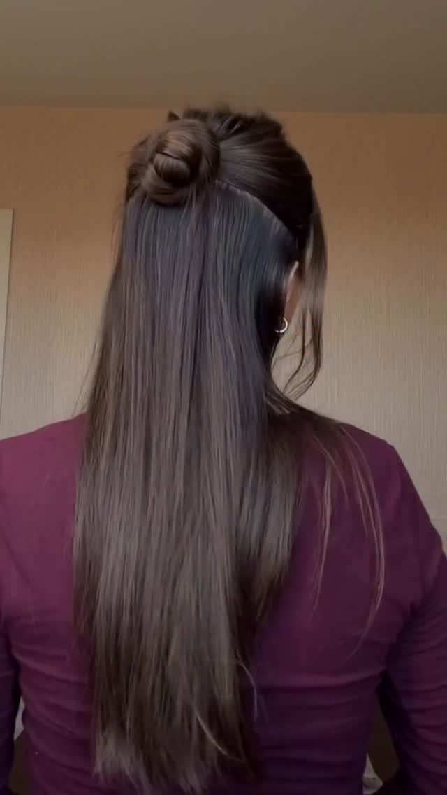 16 Long Hair Half Up Half Down Hairstyles for Real Life 16 Long brown hair styled in a half-up bun worn by a woman in a maroon shirt.