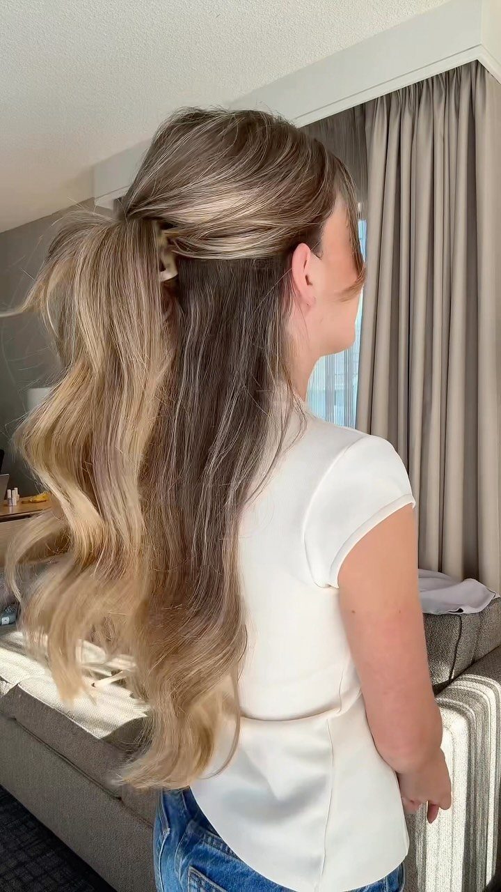 16 Long Hair Half Up Half Down Hairstyles for Real Life 10 Woman with very long wavy hair styled in a half-up, half-down hairstyle.