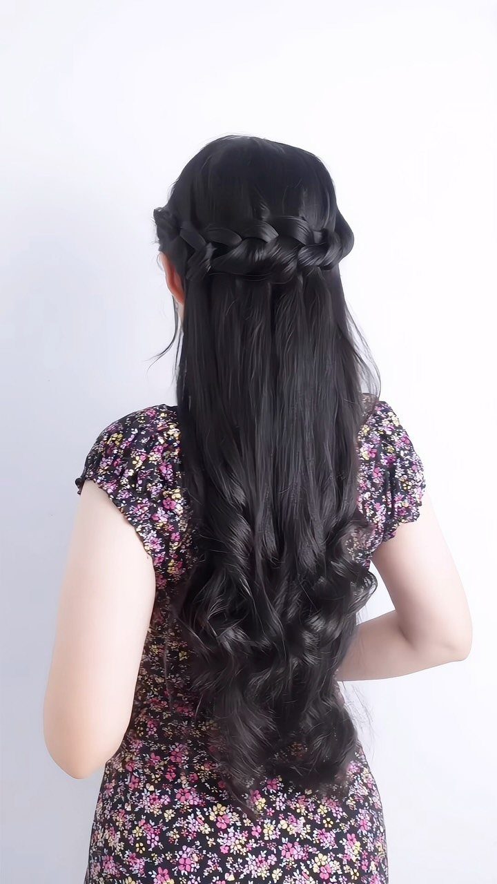 16 Long Hair Half Up Half Down Hairstyles for Real Life 11 Long dark hair styled in a twisted crown braid with loose curls flowing down the back.