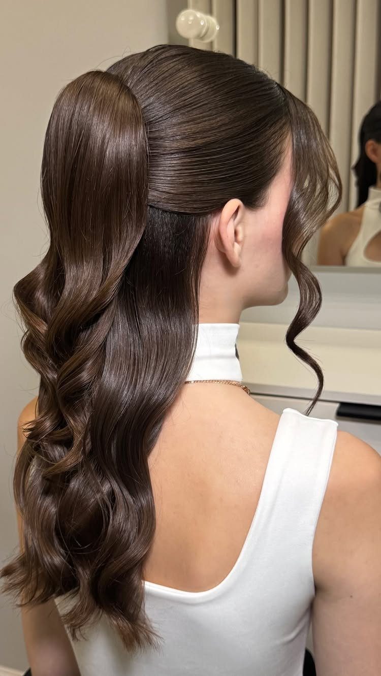16 Long Hair Half Up Half Down Hairstyles for Real Life 12 Woman with long brown hair in a voluminous half-up ponytail with wavy bottom sections.