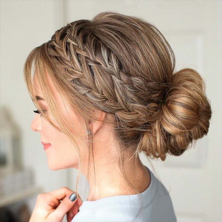 18 Low Messy Bun for Wedding Ideas with Braids and Florals 19 Woman with light brown hair in a braided low messy bun hairstyle.