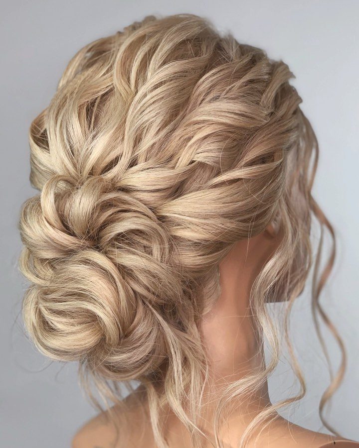18 Low Messy Bun for Wedding Ideas with Braids and Florals 18 Blonde low messy bun hairstyle with loose curls for a wedding look.
