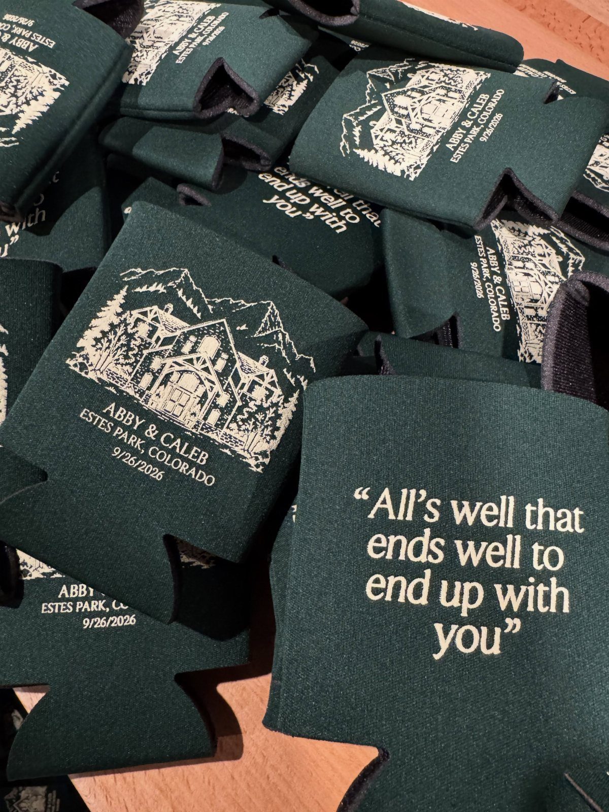 19 Mountain Wedding Ideas for Scenic, Cozy Celebrations 8 Dark green foam can coolers with white wedding text and mountain graphics.