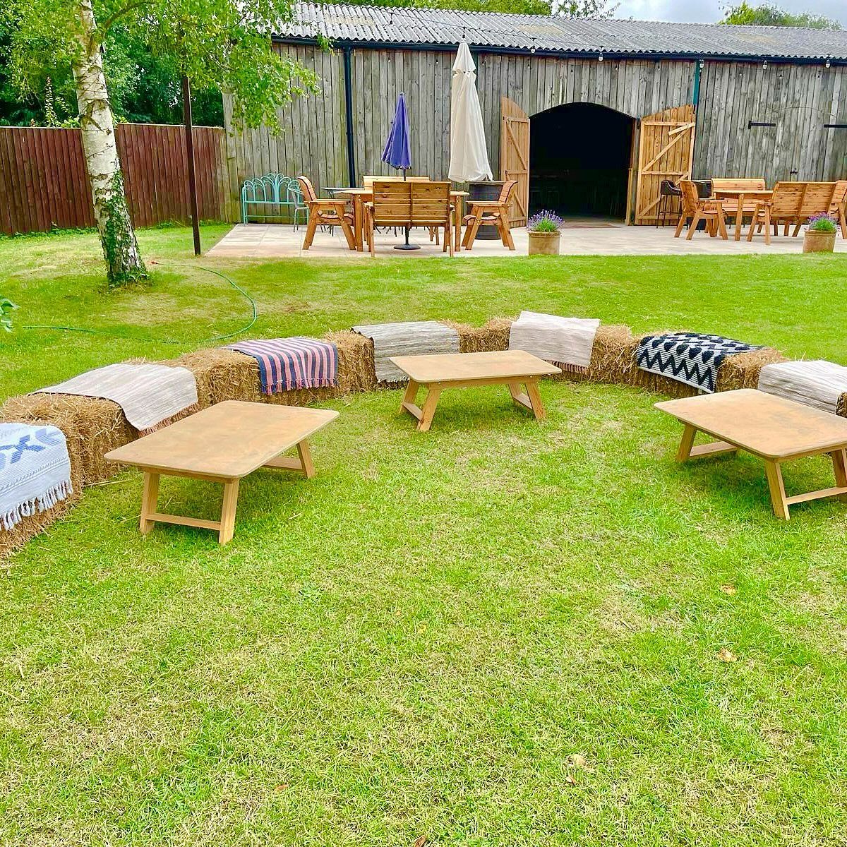 19 Mountain Wedding Ideas for Scenic, Cozy Celebrations 18 Hay bales covered with blankets arranged as rustic seating with low wooden tables.