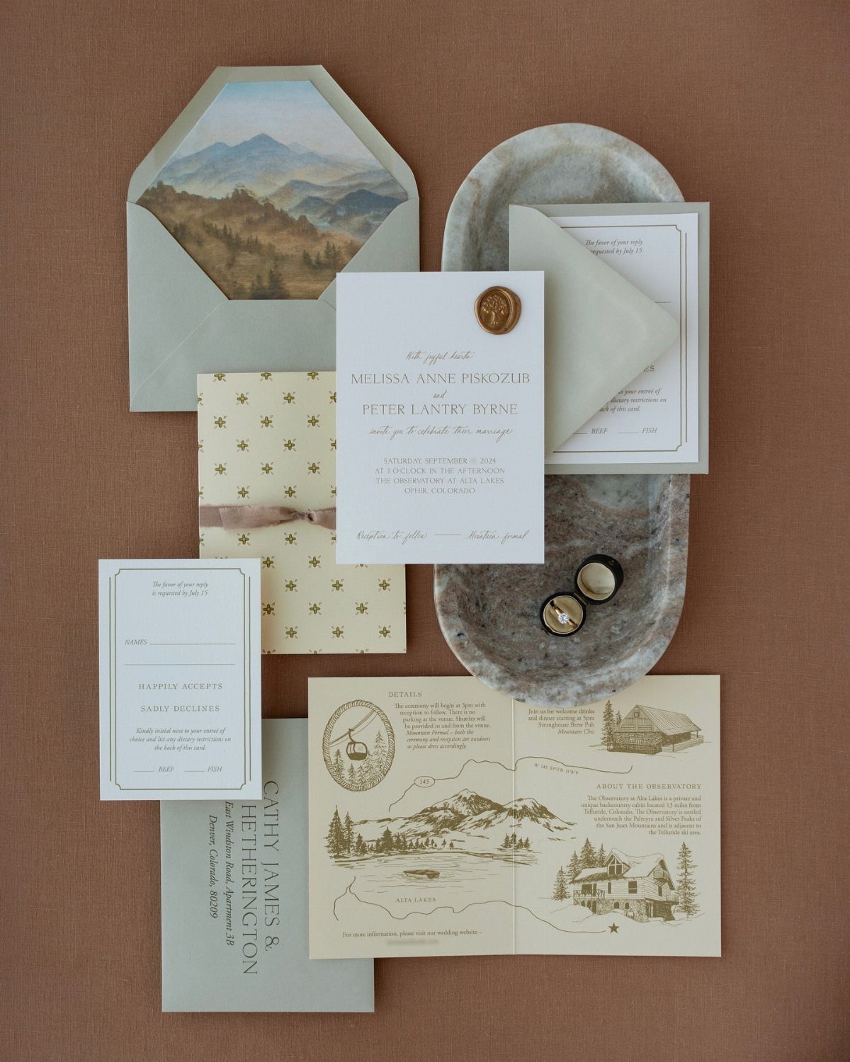 19 Mountain Wedding Ideas for Scenic, Cozy Celebrations 14 Wedding invitation suite featuring mountain landscape art, a wax seal, and illustrated map.