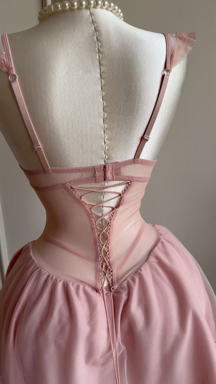 Pink satin nightgown with a lace-up corset back displayed on a white mannequin.