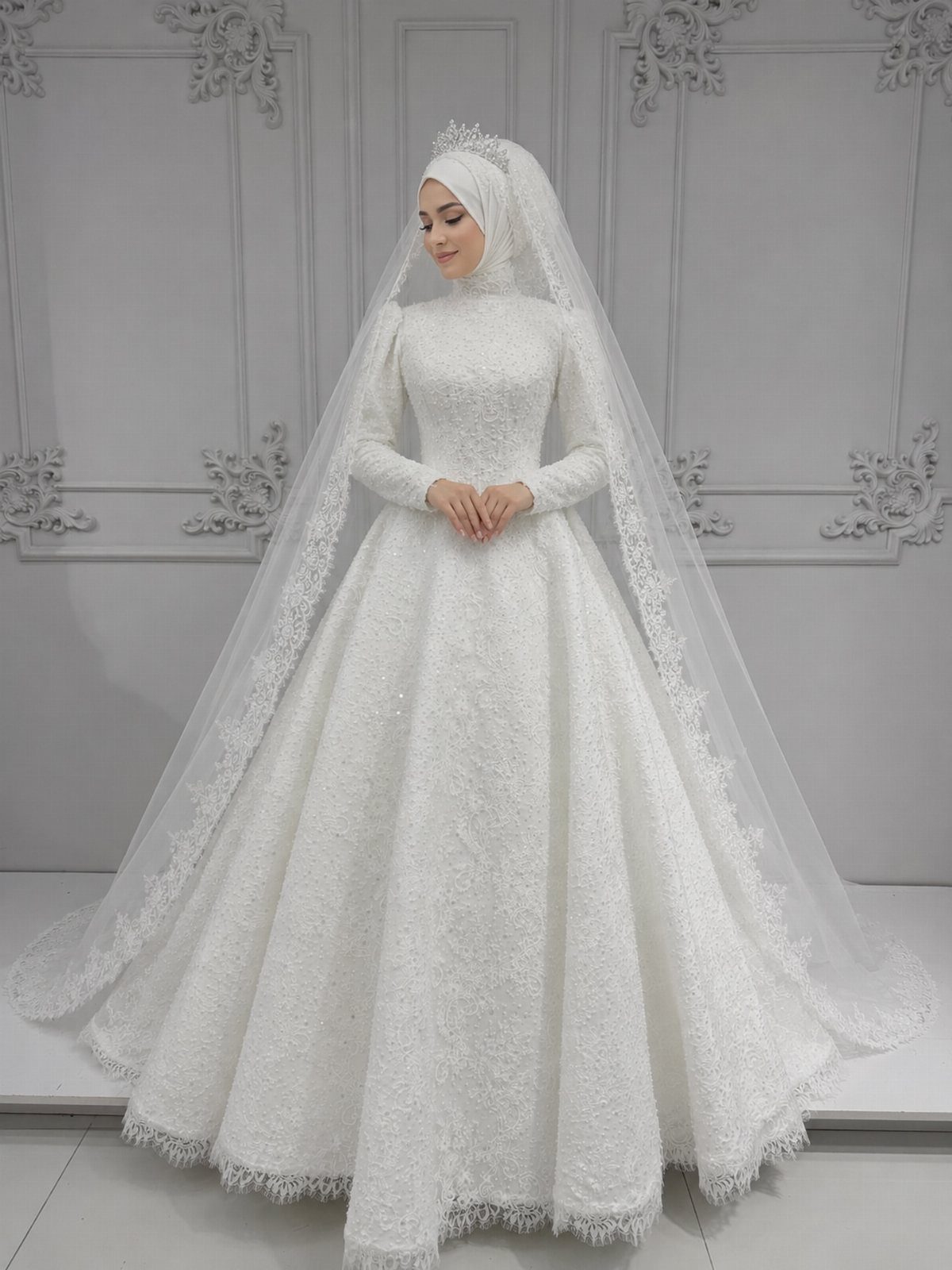 26 Nikah Dress Ideas for Your Perfect Wedding Ceremony 9 Woman in a white lace bridal gown with hijab, tiara, and long veil.
