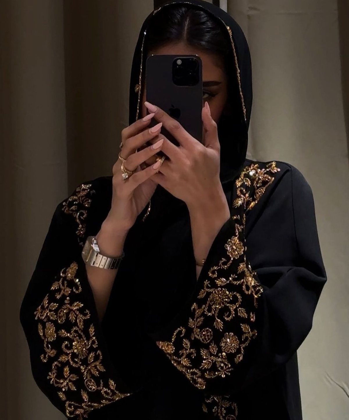 26 Nikah Dress Ideas for Your Perfect Wedding Ceremony 10 Woman in a black abaya and hijab with ornate gold floral embroidery.
