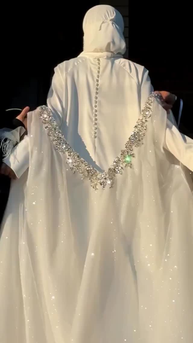 26 Nikah Dress Ideas for Your Perfect Wedding Ceremony 6 Woman wearing a white abaya with shimmering silver embellishments and a matching niqab.