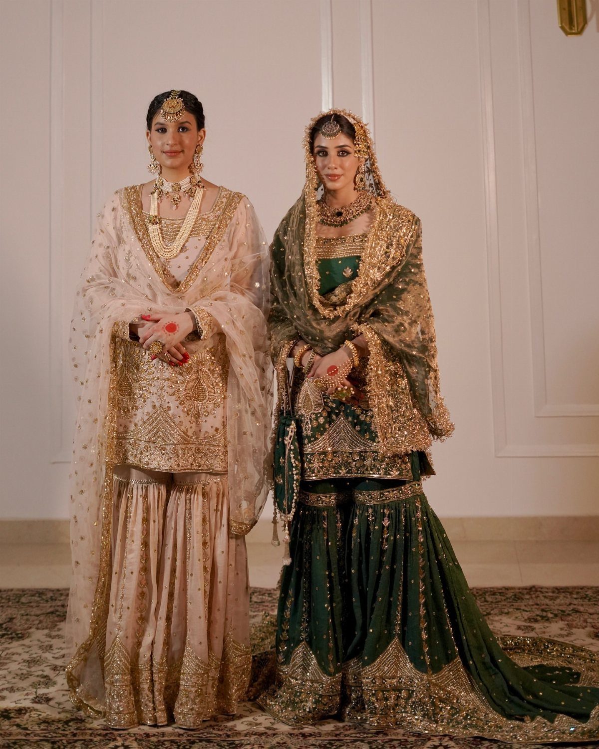 26 Nikah Dress Ideas for Your Perfect Wedding Ceremony 15 Two women wearing traditional Pakistani gharara suits in cream and dark green colors.