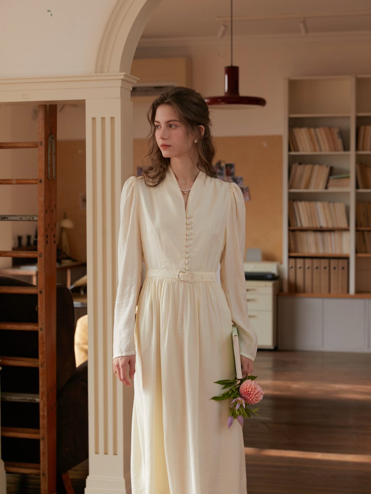 26 Nikah Dress Ideas for Your Perfect Wedding Ceremony 11 Woman in a long-sleeved pure white minimalist dress holding a small flower bouquet.