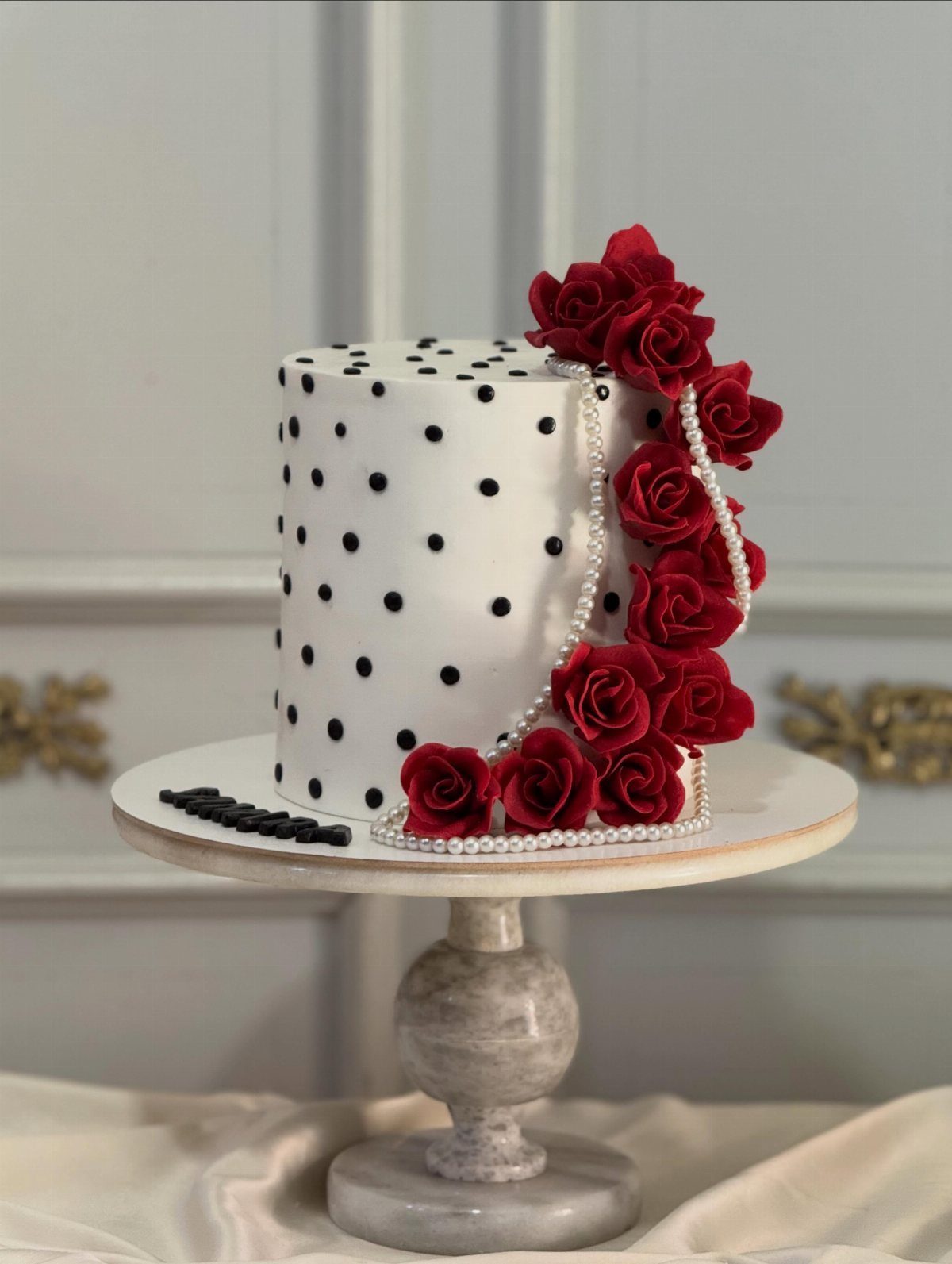 Quince Cake Ideas: 18 Designs From Florals to Butterflies 16 White cake with black polka dots, red roses, and pearl strings on a stand.