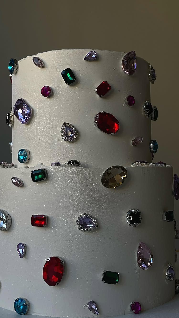 Quince Cake Ideas: 18 Designs From Florals to Butterflies 17 Two-tier white cake decorated with colorful faceted gemstones in various shapes and sizes.